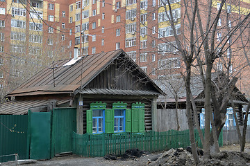 Image showing Old wooden houses against modern high-rise buildings. Tyumen, Ru