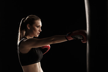 Image showing beautiful woman is boxing on black background