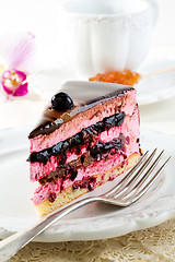 Image showing Piece of cake with souffle and blackcurrant jelly on a white pla