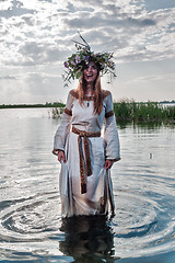 Image showing Beautiful woman with flower wreath stands in water