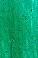 Image showing Green painted metal sheet with rivets diagonally