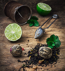 Image showing tea brew with lime and mint on wooden background 