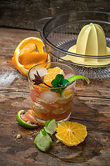 Image showing fresh juice of tropical citrus fruits on wooden background