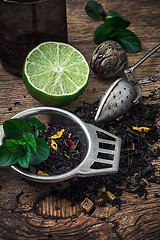 Image showing tea brew with lime and mint on wooden background 