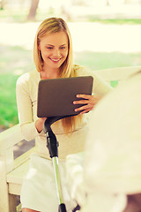 Image showing happy mother with tablet pc and stroller in park