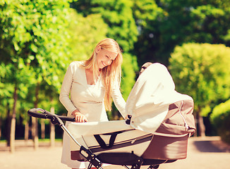 Image showing happy mother with stroller in park