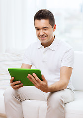 Image showing smiling man working with tablet pc at home