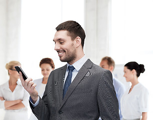 Image showing young smiling businessman with smartphone