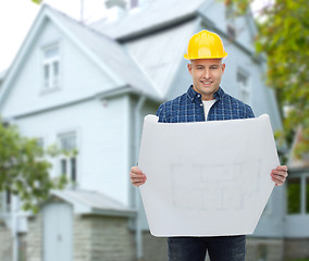 Image showing smiling builder with blueprint over house