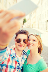 Image showing smiling couple with smartphone in city