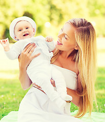 Image showing happy mother with little baby sitting on blanket