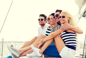 Image showing smiling friends sitting on yacht deck