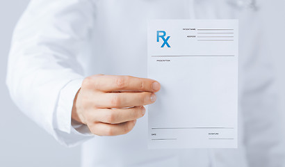 Image showing male doctor holding rx paper in hand