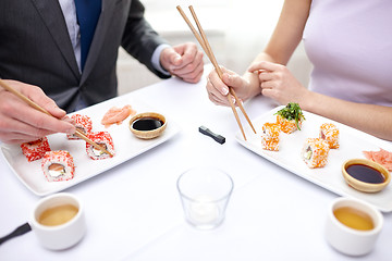 Image showing close up of couple eating sushi at restaurant