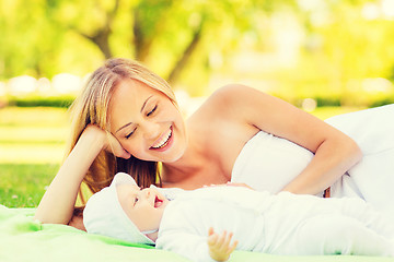 Image showing happy mother lying with little baby on blanket