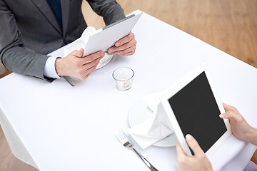 Image showing close up of couple with tablet pc at restaurant