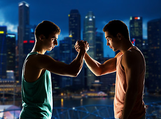 Image showing two young men arm wrestling