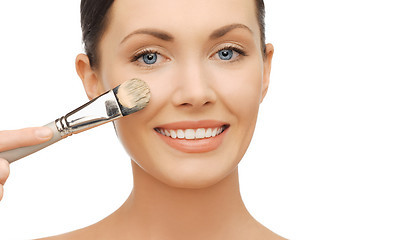 Image showing woman applying liquid foundation with brush