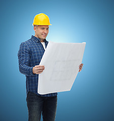 Image showing smiling male builder in helmet with blueprint