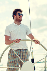 Image showing young man in sunglasses steering wheel on yacht