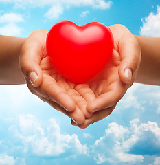 Image showing close up of female hands holding small red heart