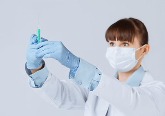 Image showing female doctor holding syringe with injection