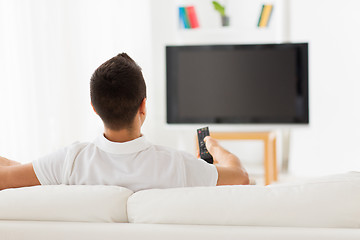 Image showing man watching tv and changing channels at home