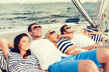 Image showing smiling friends lying on yacht deck