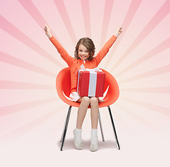 Image showing happy little girl with gift boxes sitting on chair