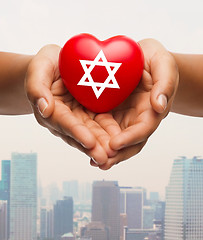 Image showing close up of hands holding heart with jewish star