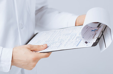 Image showing male doctor holding prescription paper in hand