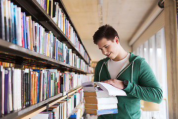 Image showing happy student or man with book in library