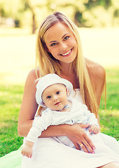 Image showing happy mother with little baby sitting on blanket