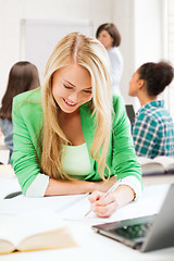 Image showing student girl writing in notebook at school