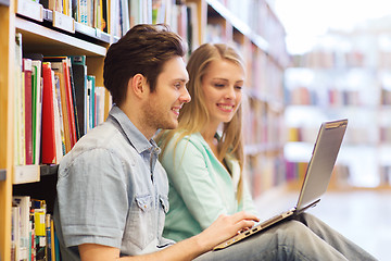 Image showing happy students with laptop in library