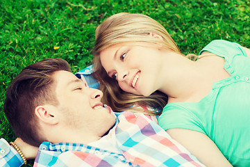 Image showing smiling couple lying on grass in park