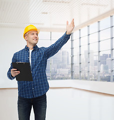 Image showing smiling male builder in helmet with clipboard