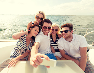 Image showing smiling friends sitting on yacht deck