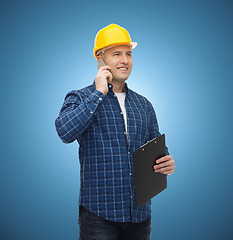 Image showing smiling male builder in helmet with clipboard