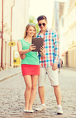 Image showing smiling couple with tablet pc in city