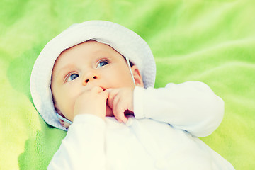 Image showing litle baby lying on floor and looking up