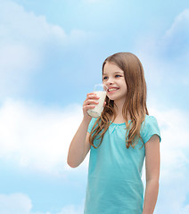 Image showing smiling little girl drinking milk out of glass