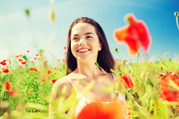 Image showing smiling young woman on poppy field