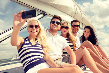 Image showing smiling friends sitting on yacht deck