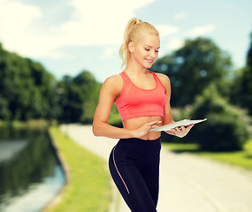 Image showing smiling sporty woman with tablet pc computer