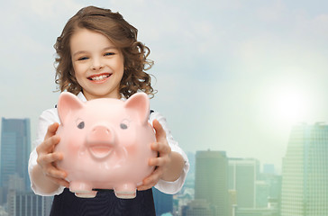 Image showing happy girl holding piggy bank 