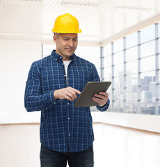 Image showing smiling male builder in helmet with tablet pc