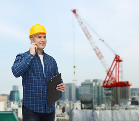 Image showing smiling male builder in helmet with clipboard