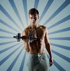 Image showing young man with dumbbell flexing biceps