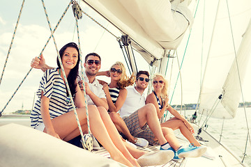 Image showing smiling friends sitting on yacht deck